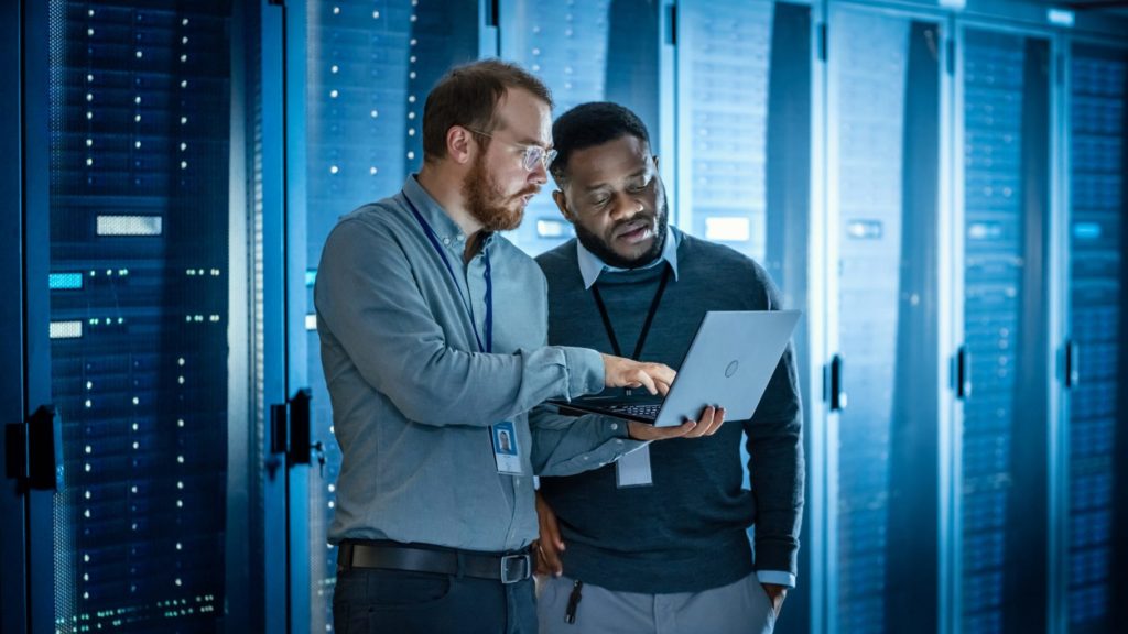 Caucasian Data Center Worker and African American Data Center Worker discussing project
